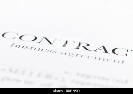 A fragment of a contract printed on paper. Word Contract close up. The buyer and the seller made a contract on paper. Selective focus. Stock Photo