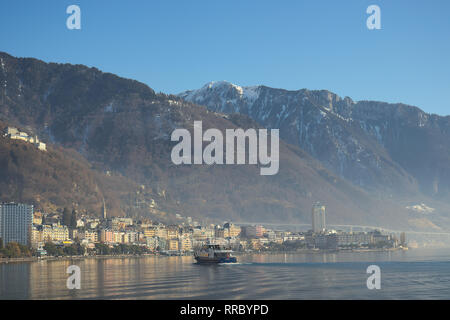 Montreux, Switzerland - 02 17, 2019: Ship cruising towards Montreux with mountains in the background. Stock Photo