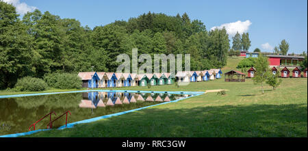 beautiful blue chalets in a summer camp for children situated near pond Stock Photo