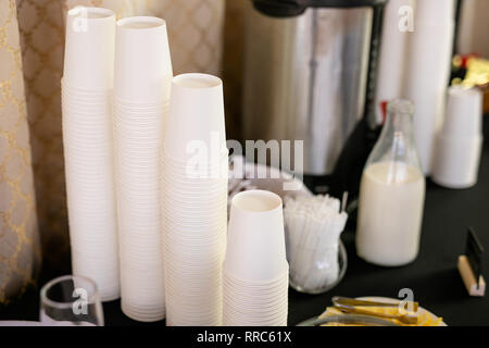 Stacks of wite paper cups, hot coffee cups, beverage cups on coffee machine in cafe. Stock Photo