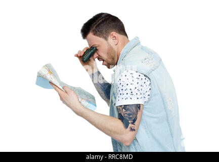 man with a map. Side view.  Isolated on white background. The traveler looks through the binoculars at the map with surprise. Stock Photo