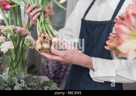 Small business. Male florist in flower shop. Floral design studio, making decorations and arrangements. Flowers delivery, creating order. The man in female profession. Gender equality concept Stock Photo