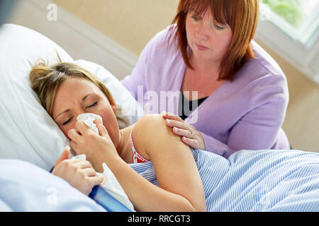 Teenage girl laid in bed with the flu Stock Photo