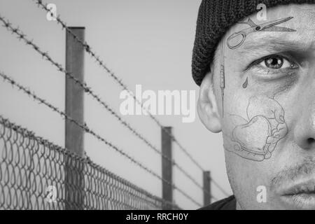 Portrait of guy with teardrop and face tattoo. Criminal, convict and prison tattoos concept. Image montage. Stock Photo