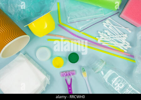 Plastic waste concept: varitety of single use objects that get thrown out every day, top view. Plastic bottle, hygiene items and plastic package depic Stock Photo