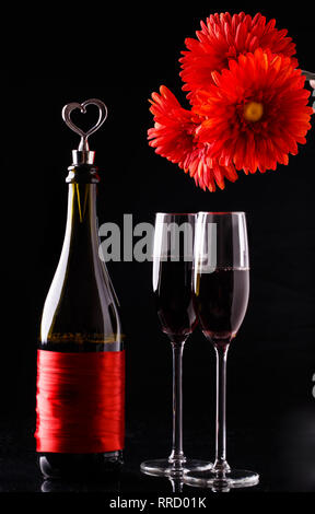 Flowers, bottle on black background Stock Photo