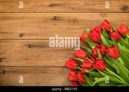 Tulips bouquet in lower right corner on rustic wood background with large copy space Stock Photo