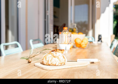 Bread on wooden board with knife on the table outside the house Stock Photo