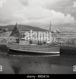 1950s, historical, small fishing boat or trawler with sails, out