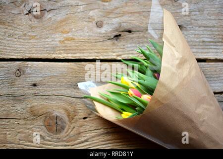 a bouquet of colored tulips on a wooden background Stock Photo