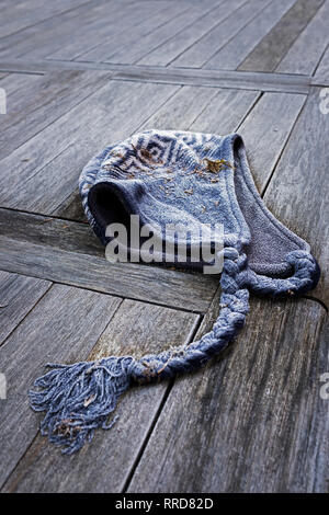 Discarded woolly hat covered with frost. Stock Photo
