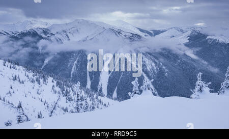 Picturesque view of peak of mountains in clouds and snow in Canada Stock Photo