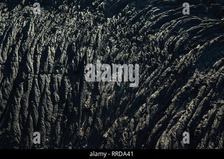 Closeup texture of dark rough rock in sunlight Stock Photo