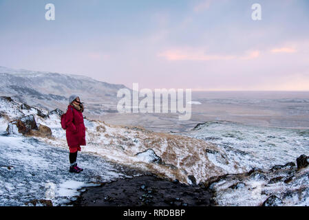 Female traveler on a sunrise winter hike in Iceland Stock Photo