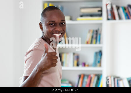 African american man with bald head showing thumb up indoors at home Stock Photo