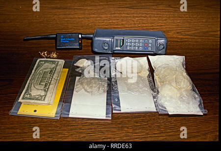 Palmer Park, Maryland, USA, 1989 Prince Georges County Police display cash cell phone, powder and crack cocaine seized from street level dealer after an undercover bust. Credit: Mark Reinstein / MediaPunch Stock Photo