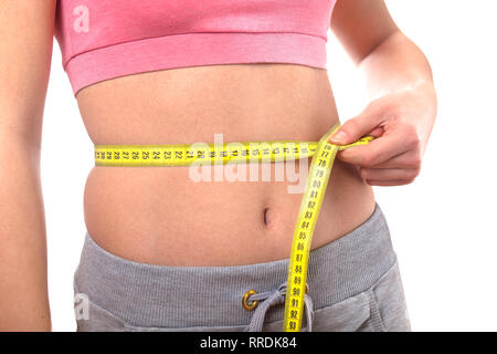 sport, fitness and diet concept, trained belly with measuring tape Stock Photo