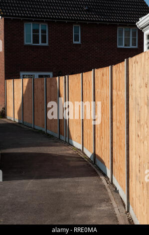 Brand new garden fencing on concrete base with concrete posts on housing estate. Stock Photo