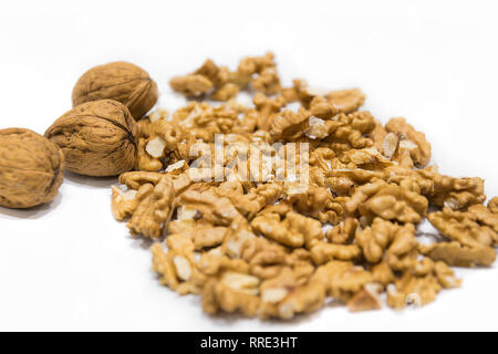 Walnut kernels and whole nutshells closeup macro, isolated on a white background. Dried fruit Stock Photo