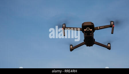 YORK, UK - FEBRUARY 21, 2019. A DJI mavic Pro 2 quadcopter drone in flight and hovering below a blue sky with copy space. Stock Photo