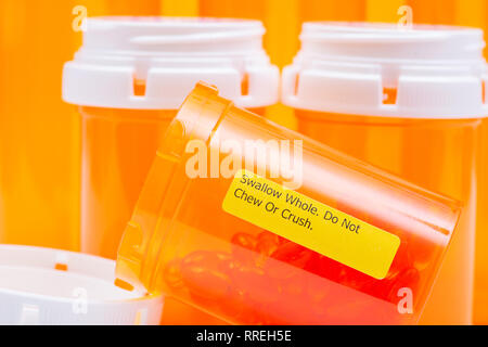 Docusate sodium soft gel capsules in orange container with SWALLOW WHOLE DO NOT CHEW OR CRUSH LABEL. Stock Photo