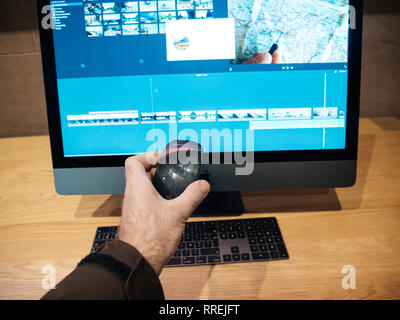 PARIS, FRANCE - JAN 10, 2018: Customer holding Magic Mouse near new Apple iMac Pro workstation computer in Apple Store - the Space Gray workstation featuring Intel Xeon CPU and Radeon Vega GPU Stock Photo