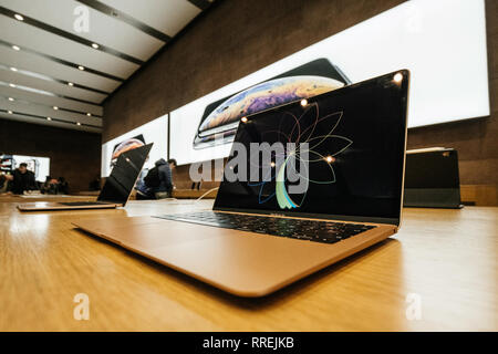PARIS, FRANCE - NOV 8, 2018: Side view of modern latest new Apple MacBook Air thin laptop featuring Retina screen and new CPU - Apple Store view with customers in background wide angle Stock Photo