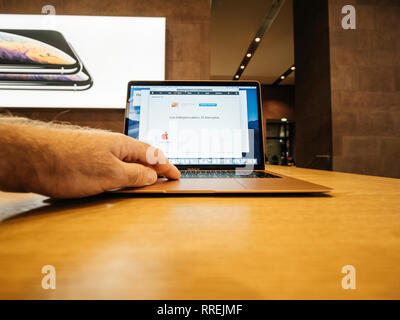 PARIS, FRANCE - NOV 8, 2018: Man working on the new Apple MacBook Air thin laptop featuring Retina screen and new CPU using the Apple Website Stock Photo