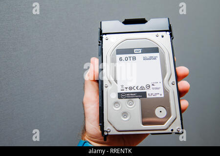 Paris, France - Jan 8, 2018: Man holding against gray background new HDD Western Digital 6tb  Caviar Black Stock Photo