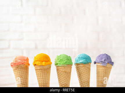 colorful rainbow ice cream cones on yellow backgound. Summer concept