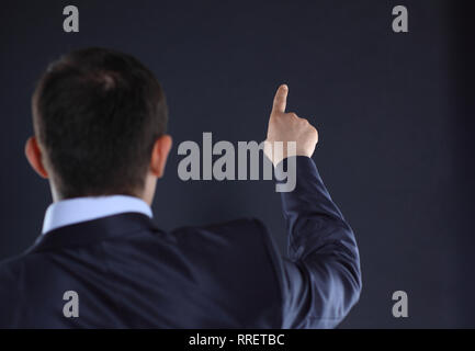 rear view.businessman pointing at copy space. black background Stock Photo