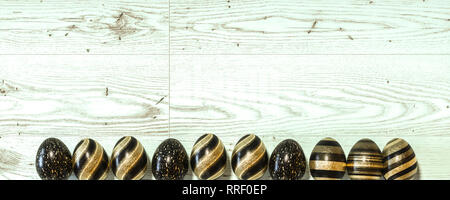 Blue, Red, green, cyan and pink colored Easter eggs balanced on its blunt end on white background with wide copy space Stock Photo