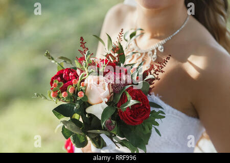 Bride Holding Bridal Bouquet With Pink and Red Roses Outdoors. Stock Photo