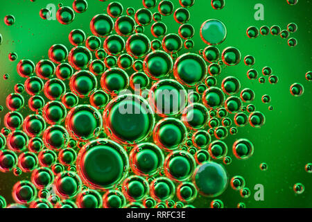 From above closeup many abstract orange and green water bubbles on glass on blurred background Stock Photo