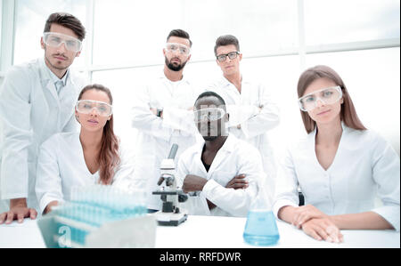 Group of young successful scientists posing for camera Stock Photo
