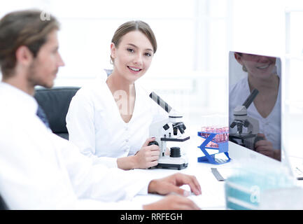 Lab expert working on a test using microscope Stock Photo
