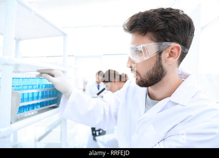 side view of focused scientist holding test tube in laboratory Stock Photo