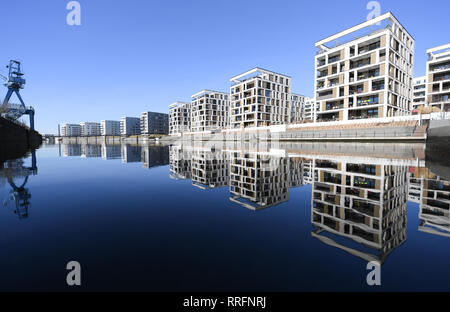 25 February 2019, Hessen, Offenbach/Main: New buildings in the new Offenbach harbour residential and commercial district are reflected in the harbour basin. The municipality plans to raise the property tax by almost 400 points to almost 1000. The planned tax rate would thus be by far the highest in the larger Hessian cities. Citizens have announced resistance to the increase. (to dpa 'Massive tax increase in Offenbach - federation demands savings' of 26.02.2019) Photo: Arne Dedert/dpa Stock Photo