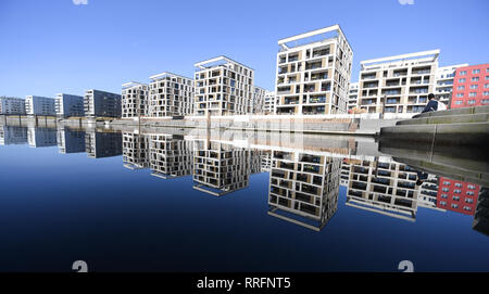 25 February 2019, Hessen, Offenbach/Main: New buildings in the new Offenbach harbour residential and commercial district are reflected in the harbour basin. The municipality plans to raise the property tax by almost 400 points to almost 1000. The planned tax rate would thus be by far the highest in the larger Hessian cities. Citizens have announced resistance to the increase. (to dpa 'Massive tax increase in Offenbach - federation demands savings' of 26.02.2019) Photo: Arne Dedert/dpa Stock Photo