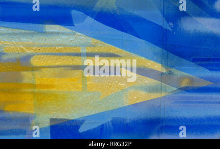 Yellow arrow, direction sign, blue background, painted on wall, abstract Stock Photo