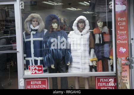 Women's clothing store window display of coats with advertising in Russian in the window on Kings highway in Brooklyn, New York. Stock Photo