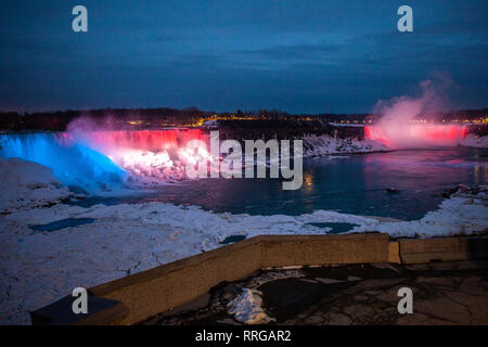 Winter frozen night view at the American side of beautiful Niagara Falls cower with colorful lights on snow and ice Stock Photo