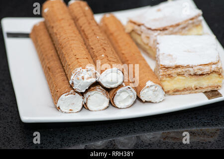 Party platter with arranged sweet desserts from a bakery on banquet table at business or wedding event venue. Sweet food, buffet. Unhealthy food. Stock Photo
