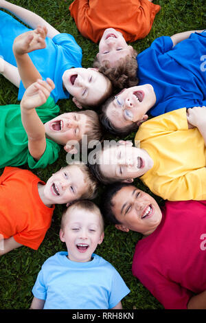 Group of Boys Laughing in Grass Outside Stock Photo