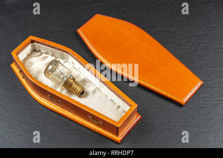 Burned Out Light Bulb popped and smoked in coffin.Concept Stock Photo