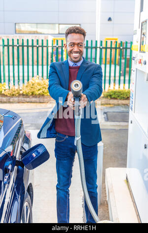 Smiling man holding a hydrogen refueling hose. Refuelling a Hydrogen car takes three minutes Stock Photo