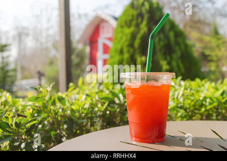 Ice tea in a plastic glass on the table. Stock Photo