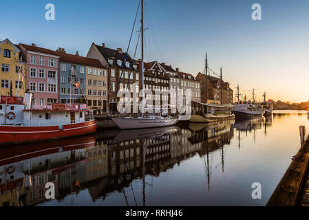 The sunrise over the calm water and the reflecting boats at Nyhavn harbor in Copenhagen, February 16, 2019 Stock Photo