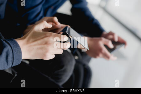 Group of diverse friends playing game on mobile phone Stock Photo