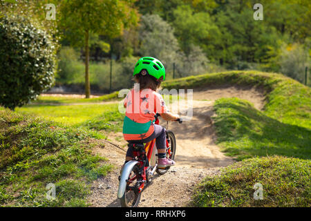 Small child is riding a bike in a bike parcours Stock Photo